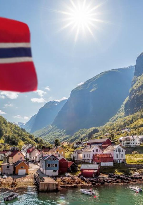Grafika przedstawiająca norweską flagę z tłem miasteczka poółożonego nad jeziorem w górach